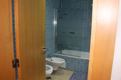 a bathroom with a toilet and a tub and a sink at Charming 3-Bed Apartment in Albufeira in Albufeira