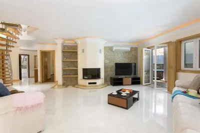 a living room with a couch and a tv at Villa Falesia Mar by Villa Plus in Olhos de Água