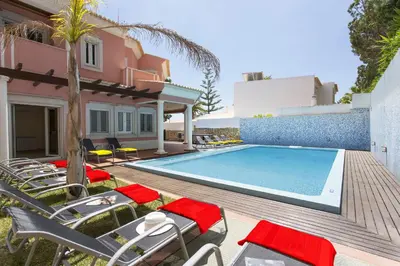 a villa with a swimming pool and chairs at Villa Falesia Mar by Villa Plus in Olhos de Água