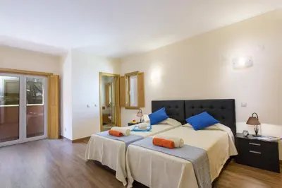 a bedroom with two beds with blue and orange pillows at Villa Falesia Mar by Villa Plus in Olhos de Água