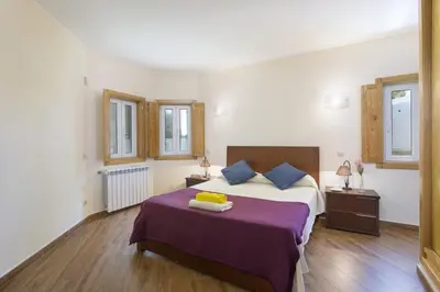 a bedroom with a large bed with a purple blanket at Villa Falesia Mar by Villa Plus in Olhos de Água
