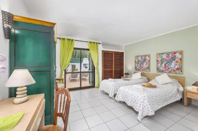 a bedroom with two beds and a table and a window at Villa Lilly by Villa Plus in Albufeira