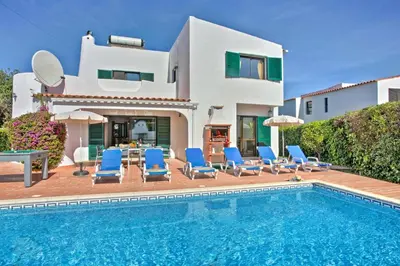 a villa with a swimming pool in front of a house at Villa Lilly by Villa Plus in Albufeira