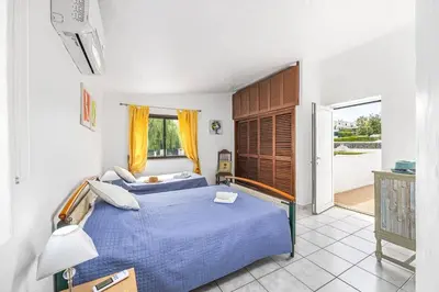 a bedroom with a blue bed and a balcony at Villa Lilly by Villa Plus in Albufeira