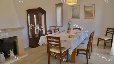 a dining room with a table and chairs and a fireplace at Villa Lilac - walking distance to beach in Albufeira