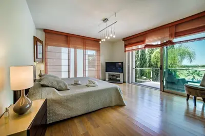 a bedroom with a large bed and a large window at Villa Laguna, Golf - Stunning house - Laguna Golf Course in Quarteira