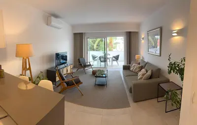 a living room with a couch and a table at Sunny Acacia Apartment in Vale do Lobo