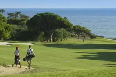 a sand bunker on a golf course near the ocean at Sunny Acacia Apartment in Vale do Lobo