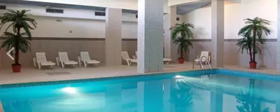 a large swimming pool in a building with palm trees at BayView Albufeira in Albufeira