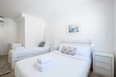 two beds in a bedroom with white walls at Atlantic Breeze Apartments by Atlantic Places in Albufeira