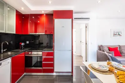 a kitchen with red cabinets and a white refrigerator at Atlantic Breeze Apartments by Atlantic Places in Albufeira