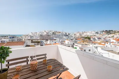 a wooden bench on a balcony with a view of a city at Atlantic Breeze Apartments by Atlantic Places in Albufeira