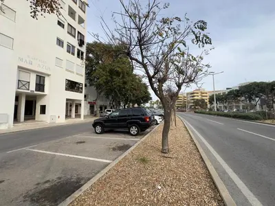 a black car parked on the side of a street at Apartamento Margarita in Quarteira