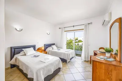 a hotel room with two beds and a window at Villa Anamar by Villa Plus in Albufeira