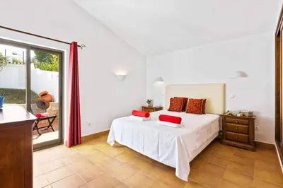 a bedroom with a bed with red pillows on it at Villa Aveiros by Villa Plus in Albufeira