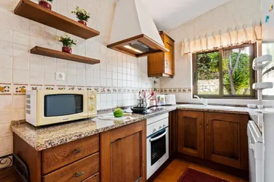 a kitchen with a microwave and a television on a counter at Villa Aveiros by Villa Plus in Albufeira