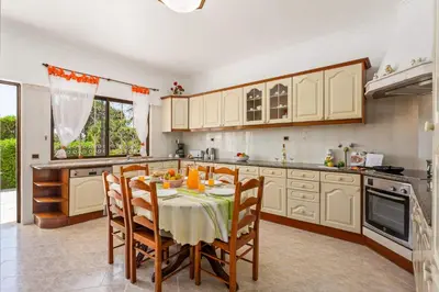 a kitchen with a table with chairs and a tableablish at Villa Barreto by Villa Plus in Pêra