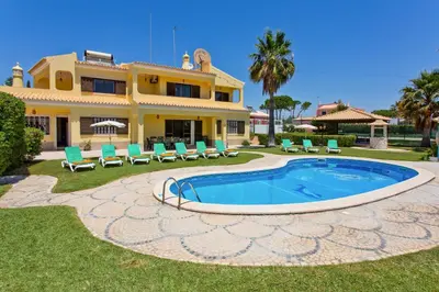 a villa with a swimming pool in front of a house at Villa Barreto by Villa Plus in Pêra