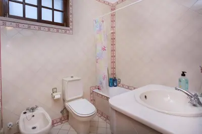a bathroom with a toilet and a sink and a tub at Villa Elanor by Villa Plus in Albufeira