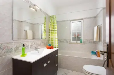 a bathroom with a sink and a tub and a toilet at Villa Gale Palm by Villa Plus in Albufeira