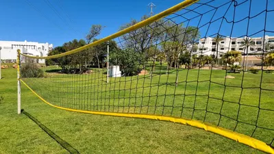 a soccer goal with a yellow net in a field at Green and Blue View Apartment in Albufeira