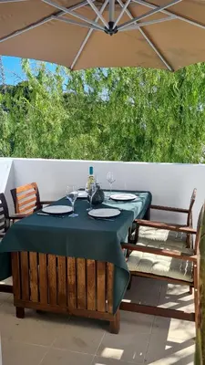 a table and chairs under an umbrella on a patio at Green and Blue View Apartment in Albufeira