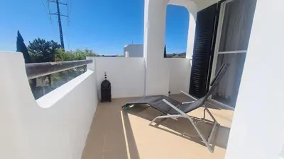 a chair sitting on the balcony of a house at Green and Blue View Apartment in Albufeira