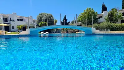 a large pool of blue water with a blue bridge at Green and Blue View Apartment in Albufeira