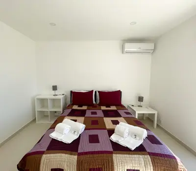 a bedroom with a large bed with two tables at Casa Rosa - Vilamoura in Vilamoura