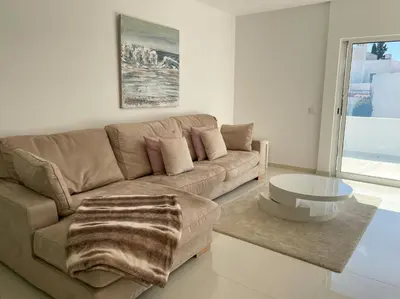 a living room with a brown couch and a table at Casa Rosa - Vilamoura in Vilamoura