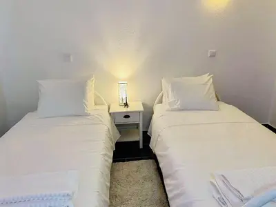 two beds sitting next to each other in a room at Albufeira Beach side Apartment in Albufeira