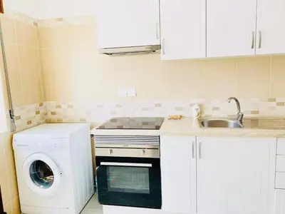 a kitchen with a washing machine and a sink at Albufeira Beach side Apartment in Albufeira
