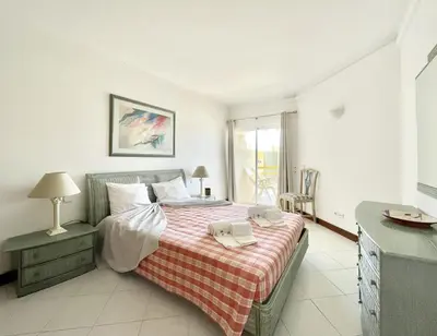 a bedroom with a bed with a red and white blanket at Alcharb - Pool & City Center - Vilamoura in Quarteira