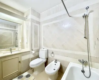 a white bathroom with a toilet and a sink at Alcharb - Pool & City Center - Vilamoura in Quarteira