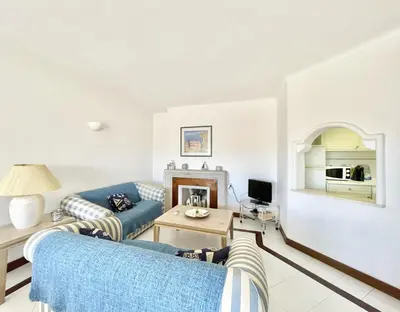 a living room with two blue couches and a table at Alcharb - Pool & City Center - Vilamoura in Quarteira