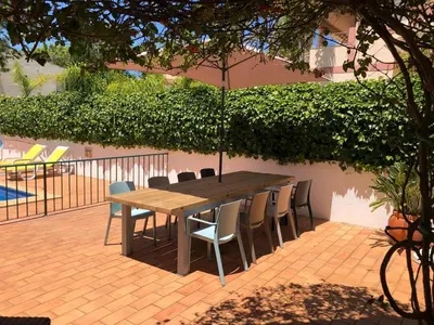 a wooden table and chairs with an umbrella on a patio at Villa Nox in Brejos