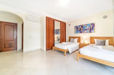 a bedroom with two beds and a large window at Villa Thetis by Atlantic Places in Albufeira