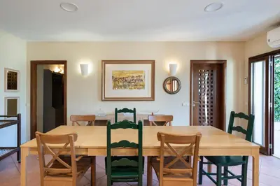 a dining room with a wooden table and chairs at Holiday villa in elite residential area of Faro in Faro
