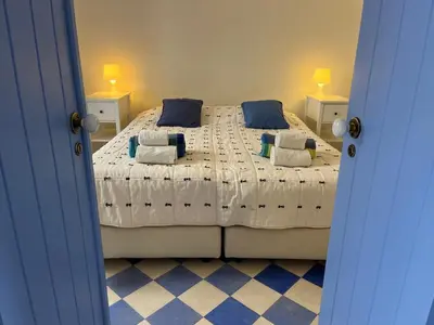a bedroom with a large bed with blue pillows at Casa da Praia in Albufeira