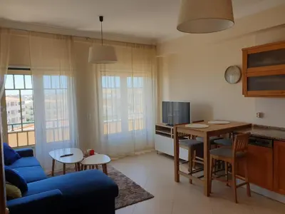a living room with a blue couch and a table at Oura Beach T1 apartment Coral , close to the Strip, Swimming Pool, Wi Fi, A/C in Albufeira