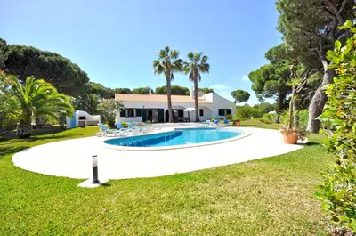 a swimming pool with chairs and a house at Close to Beaches and All Amenities, Private Pool, Free AC and Wifi in Quarteira