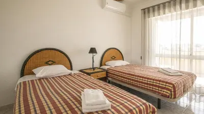 a kitchen with white cabinets and a counter with two chairs at Palmeira Gale - WIFI - Pool - Lux - BY BEDZY in Albufeira