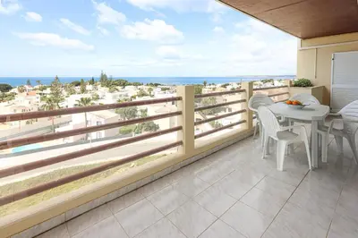 a living room with a table and chairs and a television at Palmeira Gale - WIFI - Pool - Lux - BY BEDZY in Albufeira