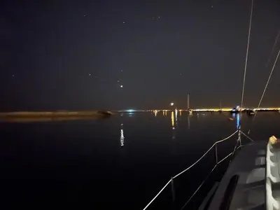 a full moon rising over a body of water at Barco Casa Catamarã Sleepandboat in Faro