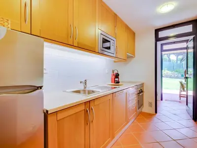 a kitchen with wooden cabinets and a sink at AL - Apartamento Vila Sol F5 AE in Vilamoura