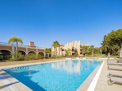 a swimming pool with lounge chairs and a resort at AL - Apartamento Vila Sol F5 AE in Vilamoura