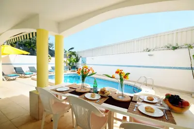 a dining room with a table and a pool at Villa Cubos by Villa Plus in Albufeira