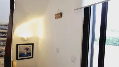 a hallway with a picture on the wall and a clock on the wall at Villa charmosa V3 junto à praia e à Marina de Vilamoura in Quarteira