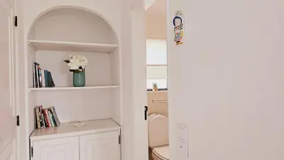 a bathroom with a toilet and a shelf with books at Villa charmosa V3 junto à praia e à Marina de Vilamoura in Quarteira