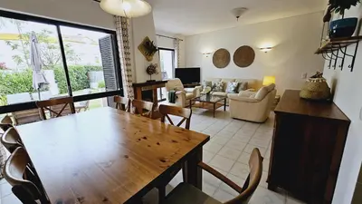 a living room with a wooden table and chairs at Villa charmosa V3 junto à praia e à Marina de Vilamoura in Quarteira